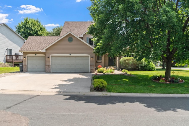 view of front of home featuring driveway, an attached garage, and a front lawn