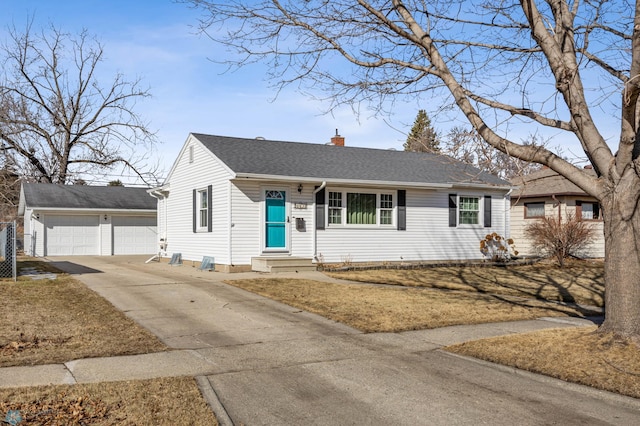 view of front of home with an outbuilding, entry steps, roof with shingles, a garage, and a chimney