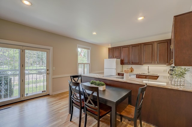 355 Laurel Ave, Saint Paul, MN 55102 - kitchen featuring freestanding refrigerator, light wood-style floors, light countertops, a peninsula, and recessed lighting