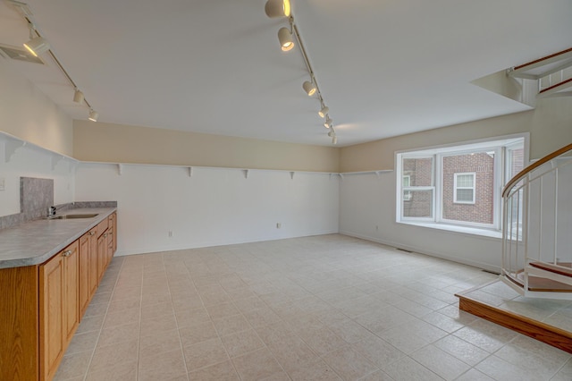 355 Laurel Ave, Saint Paul, MN 55102 - unfurnished living room with rail lighting, light tile patterned floors, and stairway