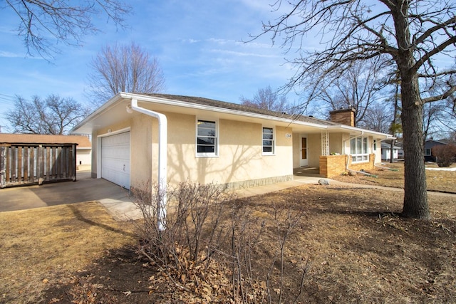 view of home's exterior featuring stucco siding, driveway, a porch, a garage, and a chimney