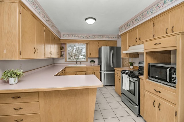 kitchen with under cabinet range hood, a sink, appliances with stainless steel finishes, a peninsula, and light countertops