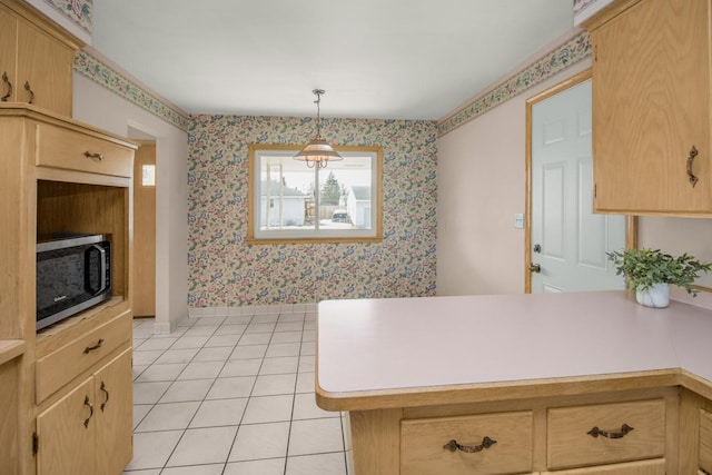 kitchen with light brown cabinets, stainless steel microwave, a peninsula, light tile patterned flooring, and wallpapered walls