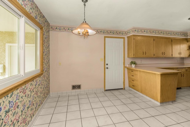 kitchen featuring light tile patterned floors, wallpapered walls, a peninsula, and light countertops