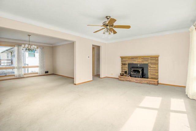 unfurnished living room with ceiling fan with notable chandelier, carpet, baseboards, and ornamental molding