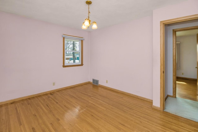 empty room with light wood-style flooring, baseboards, and visible vents