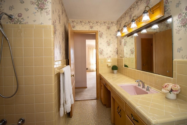 full bathroom with wallpapered walls, vanity, and wainscoting