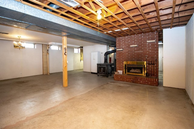 below grade area featuring a brick fireplace and a wood stove