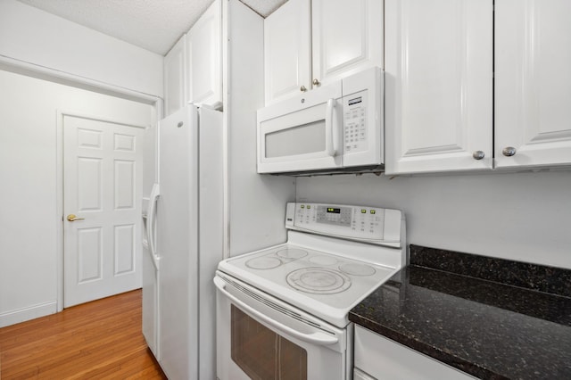 kitchen featuring dark stone countertops, a textured ceiling, white cabinetry, white appliances, and light wood-style floors