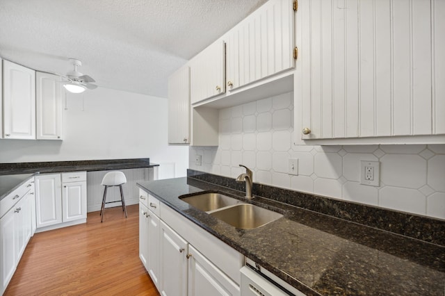 kitchen featuring white cabinetry, light wood-style floors, and a sink