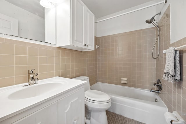 bathroom with tile patterned floors, toilet, tile walls, shower / bath combination, and vanity