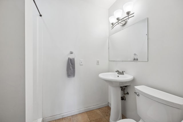 bathroom with tile patterned floors, toilet, and baseboards