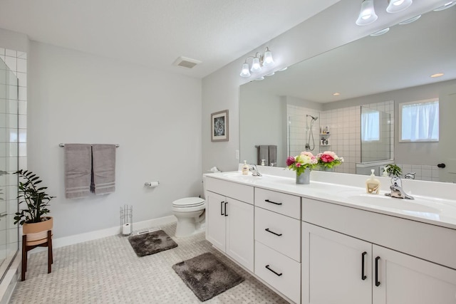 bathroom with tiled shower, a sink, visible vents, and tile patterned floors