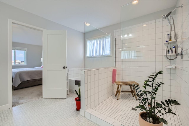 ensuite bathroom featuring connected bathroom, tile walls, and a walk in shower