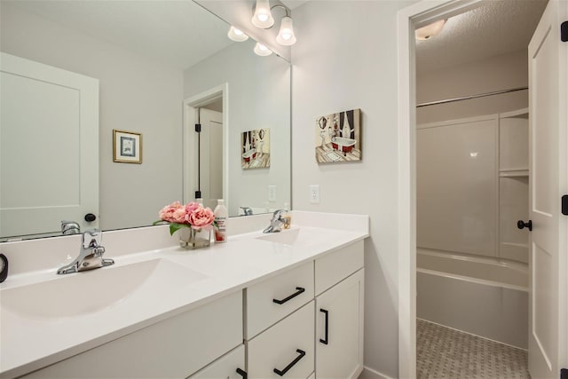 bathroom featuring  shower combination, a sink, a textured ceiling, and double vanity