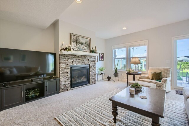 carpeted living room featuring a textured ceiling, a fireplace, and recessed lighting