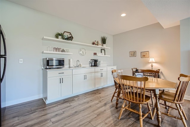 dining room featuring baseboards, recessed lighting, and light wood-style floors