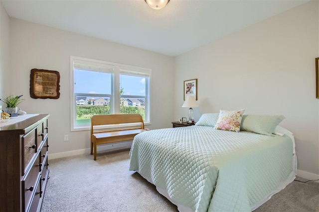 bedroom with baseboards and light colored carpet