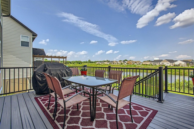 deck with a water view, grilling area, and outdoor dining area