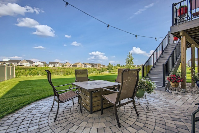 view of patio / terrace featuring outdoor dining space, stairway, and a residential view