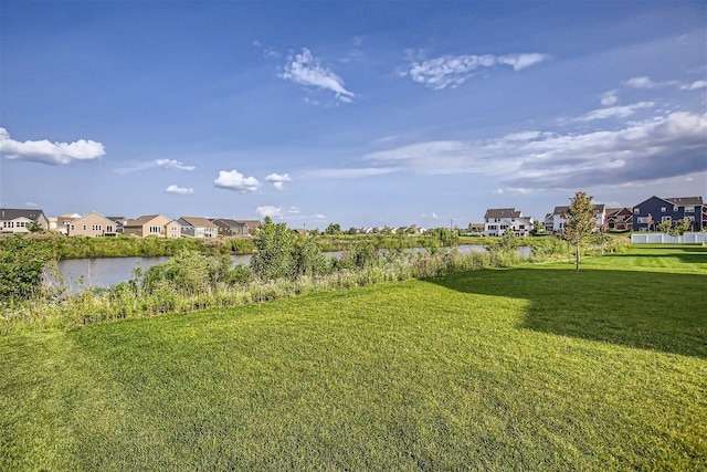 view of yard featuring a residential view and a water view