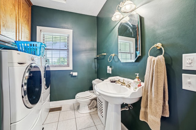 bathroom with toilet, washing machine and dryer, baseboards, and tile patterned floors