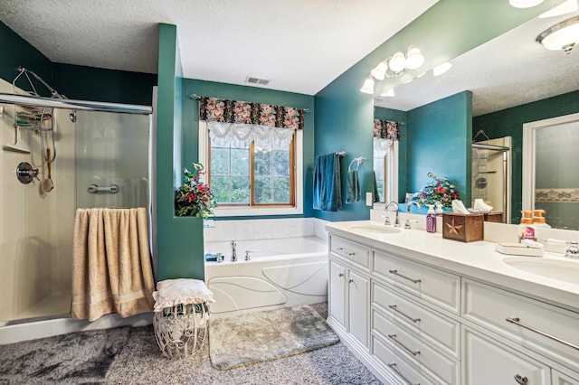 bathroom featuring a garden tub, a sink, a shower stall, and double vanity