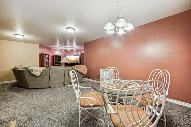 dining room featuring a textured ceiling, a chandelier, carpet flooring, and baseboards