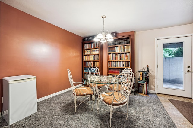 carpeted dining room featuring a notable chandelier and baseboards