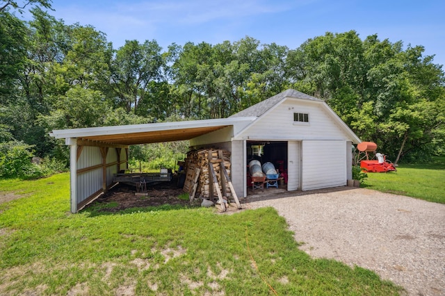 detached garage featuring a carport and gravel driveway