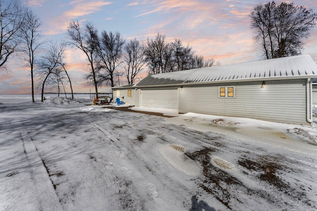 snow covered property with a garage