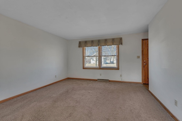 empty room with baseboards and light carpet