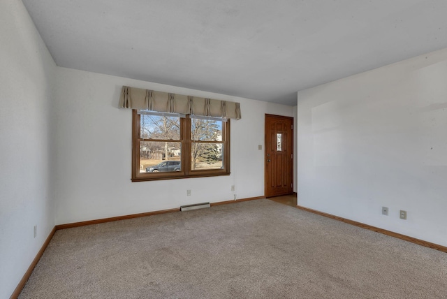 empty room with carpet flooring, baseboards, and visible vents