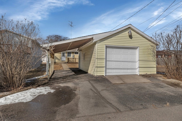 exterior space with a detached garage, an outbuilding, and driveway