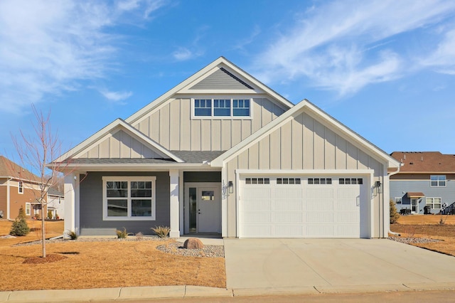 view of front of home with a garage, driveway, board and batten siding, and roof with shingles