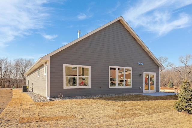 rear view of house with a lawn and cooling unit