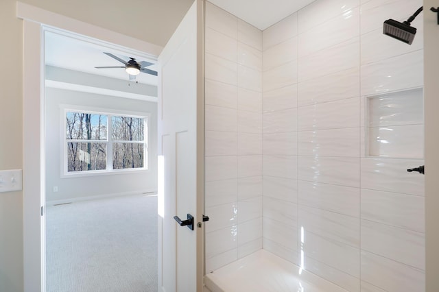 full bathroom featuring ceiling fan and a tile shower