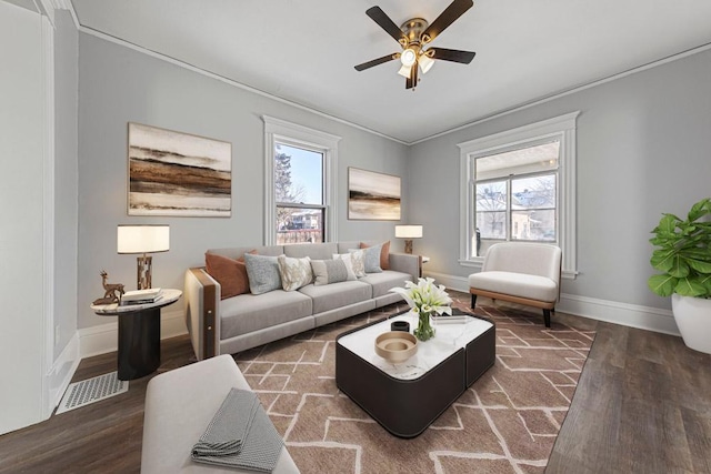 living room featuring baseboards, visible vents, ceiling fan, ornamental molding, and wood finished floors