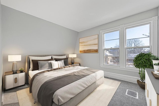 bedroom featuring visible vents, light carpet, and baseboards