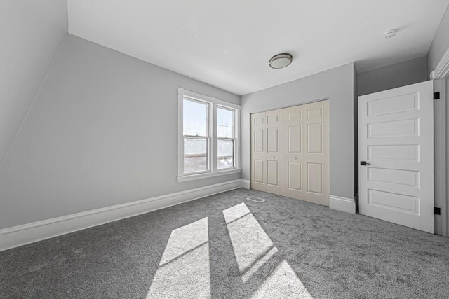 unfurnished bedroom featuring carpet, visible vents, baseboards, and a closet