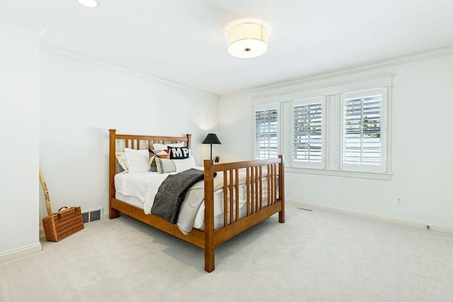 carpeted bedroom with visible vents, baseboards, and ornamental molding