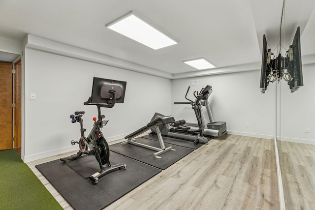 exercise room with wood finished floors and baseboards