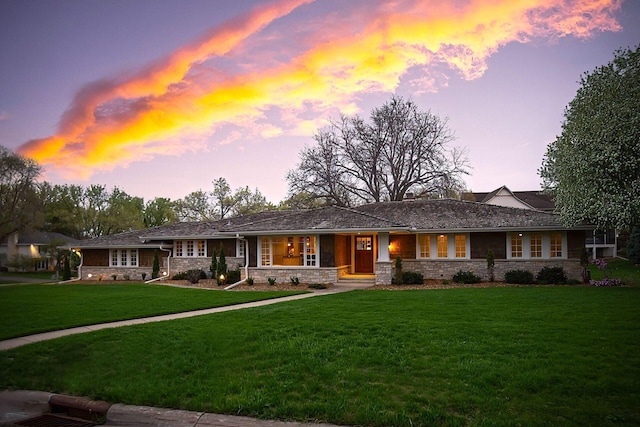 view of front of home with a yard and stone siding