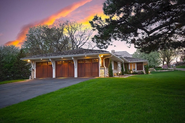 view of front facade featuring aphalt driveway, stone siding, a garage, and a front lawn