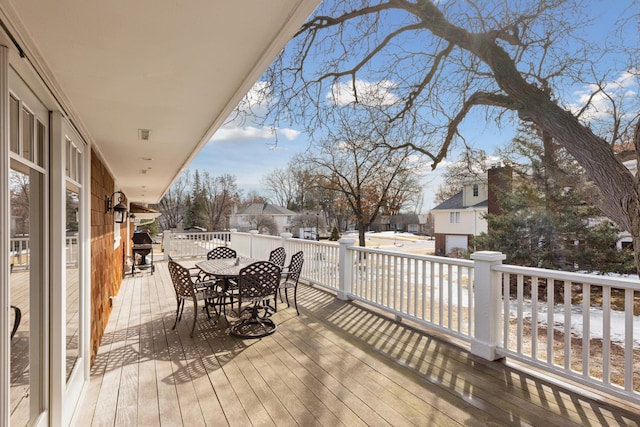 wooden deck featuring outdoor dining area and a residential view