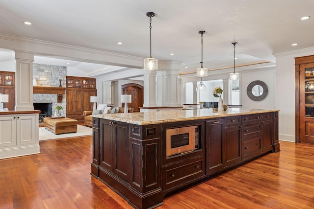 6601 Dovre Dr, Edina, MN 55436 - kitchen featuring decorative columns, dark wood-type flooring, a stone fireplace, hanging light fixtures, and recessed lighting