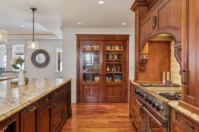 6601 Dovre Dr, Edina, MN 55436 - kitchen featuring double oven range, light wood finished floors, hanging light fixtures, light stone counters, and crown molding