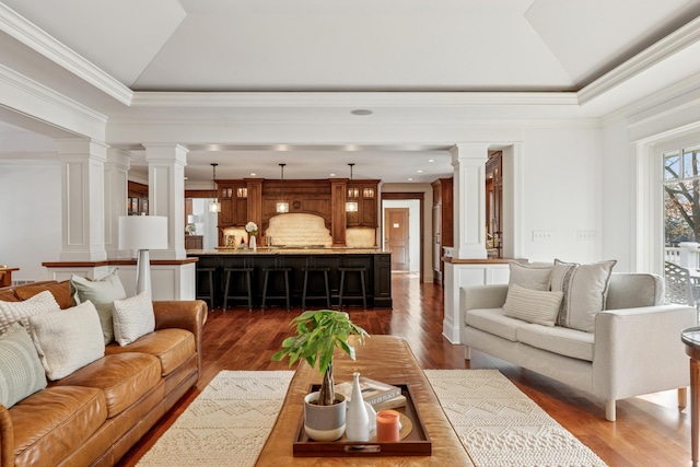 6601 Dovre Dr, Edina, MN 55436 - living area featuring decorative columns, ornamental molding, vaulted ceiling, dark wood finished floors, and a tray ceiling