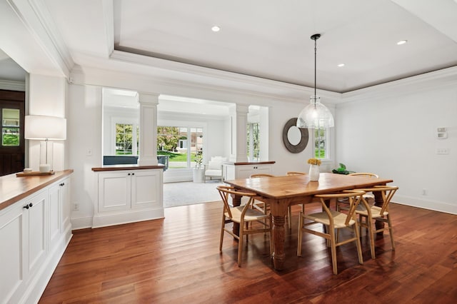 6601 Dovre Dr, Edina, MN 55436 - dining room featuring decorative columns, a raised ceiling, dark wood-style floors, crown molding, and baseboards