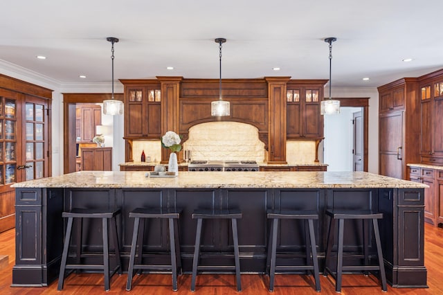 6601 Dovre Dr, Edina, MN 55436 - kitchen featuring a spacious island, a kitchen bar, backsplash, wood finished floors, and glass insert cabinets
